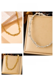 Detailed view of intertwined gold and silver beaded chains with twisted metal structure