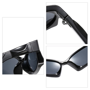 Y2K futuristic black sunglasses featuring thick frames and metal hinge details for street style