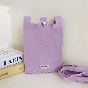 Detail view of the soft lavender knitted texture and fabric strap on a mini crossbody phone bag