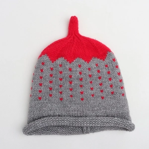 Detail of red and grey knit hat with heart jacquard pattern and rolled brim for kids