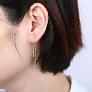 Close-up of minimalist S925 silver tassel earring line on model's ear showing slim fit