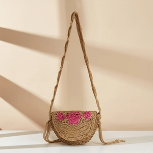 Handmade straw crossbody bag with pink crochet flowers and side tassels for beach holidays
