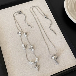 Detail of star-themed pearl necklace and planet pendant with sparkling zircon accents