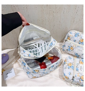 Detail view of open quilted floral toiletry bag showing interior storage for brushes