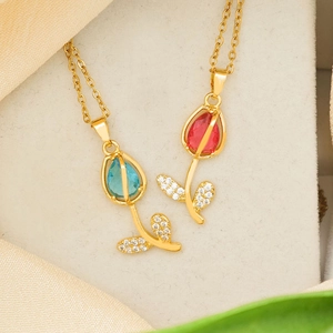 Elegant gold tulip pendant necklaces with opal stones in blue and red on silk background