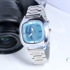Detail of a men's cushion-face quartz watch with light blue dial and silver band.