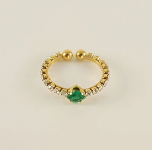 Detail of adjustable gold ring featuring emerald green crystal and paved diamonds