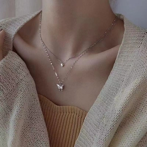 Double-layered sparkling butterfly pendant necklace for women on model neck