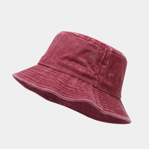 Detail of washed cotton bucket hat showing metal ventilation eyelets and stitched brim