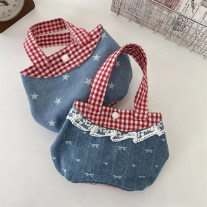 Dettaglio di mini borse in denim con bordo in pizzo e motivi a quadretti rossi e blu