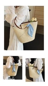 Close-up of straw woven tote with leather handles and a blue striped silk scarf detail