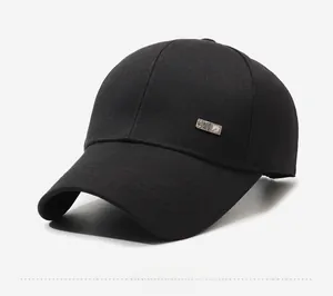 Detailopname van een zwarte honkbalpet met een zilveren metalen logo aan de zijkant