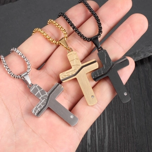 Detailed view of silver, gold, and black stainless steel cross necklaces with diamond accents