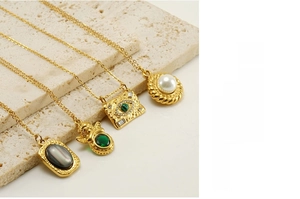 Detail of vintage 18K gold-plated stainless steel necklaces with natural stone charms