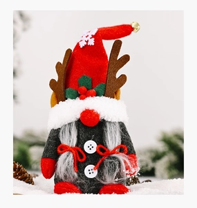 Detail of Christmas gnome plush with red hat, brown antlers and braids in snowy scene