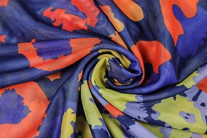 Gros plan sur tissu en résille imprimé léopard coloré avec motifs abstraits orange et bleu