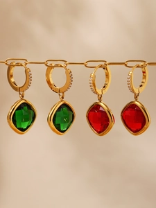 Vue détaillée de boucles d'oreilles dorées avec pierres précieuses émeraude et rubis