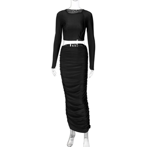 Dettaglio del crop top nero a maniche lunghe e del set gonna lunga aderente arricciata