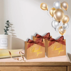 Gros plan de sacs cadeaux de mariage en papier brun avec lettrage Thank You doré