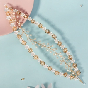 Macro detail of handmade bridal headband with gold wires, white flowers and pearls