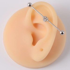16G stainless steel industrial barbell earring with five clear crystals on silicone ear