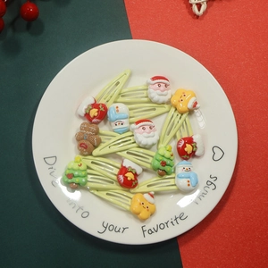 Flat lay of 10 Christmas themed resin hair clips with Santa and tree motifs on a plate