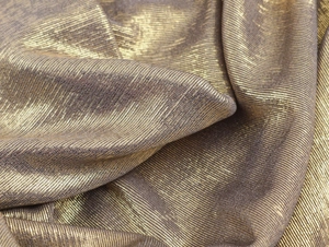 Detailed macro view of gold metallic fabric with horizontal texture and elegant pleats
