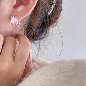 Detailed close-up of multilayer 925 sterling silver hoop earrings on a model's ear