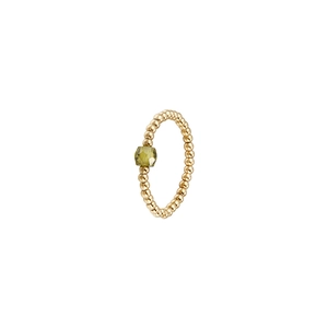 Macro detail of elastic stainless steel gold bead ring with olive green zircon gemstone