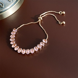 Detail shot of rose gold adjustable bracelet with pink oval zircon gems on leather