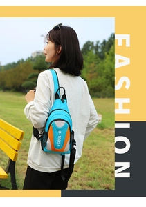 Detail of blue outdoor chest bag with orange accents showing side mesh pocket and logo