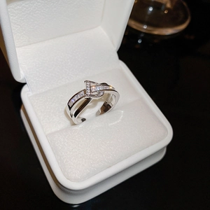 Macro detail of interlocking double-layer silver ring with cubic zirconia in a gift box