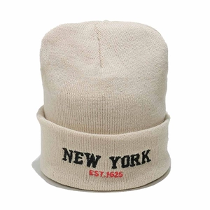 Close-up of the black New York and red EST. 1625 embroidery on the cream beanie cap