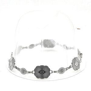 Detail of silver bohemian hollow flower metal chain belt accessory on straw hat