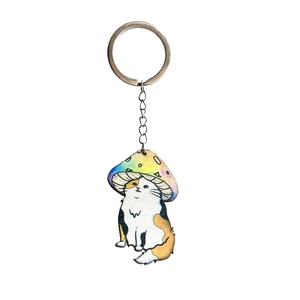 Detailed close-up of a tricolor cat keychain wearing a colorful rainbow mushroom hat