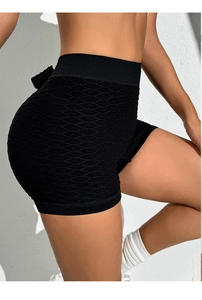 Close-up of black high-waisted yoga shorts with honeycomb texture and push-up effect