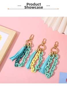 Detailed view of colorful acrylic chain keychains with tassels on a decorative background