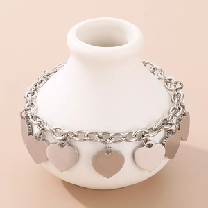 Detailed view of silver stainless steel chain bracelet with smooth heart charms