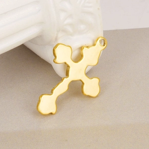 Close-up of a polished gold cross pendant with top hanging ring for DIY jewelry making