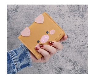 Detailed close-up of cute yellow cartoon pig wallet showing heart-shaped ears and PU texture
