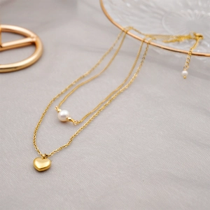 Double-layered gold titanium steel necklace with heart pendant and freshwater pearl detail