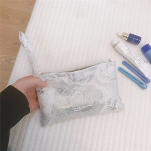 Detail of silver rose jacquard canvas mini handbag with zipper and elegant texture