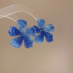 Macro shot of blue gradient crystal flower earrings with sparkling pavé rhinestones