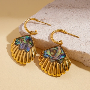 Macro detail of gold stainless steel shell earrings with colorful abalone inlay on stone