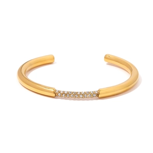 Dettaglio di un bracciale rigido placcato oro 18K con intarsio di strass bianchi multi-fila