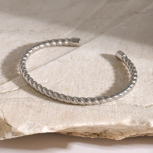 Macro view of silver twisted rope texture on adjustable stainless steel open cuff bracelet