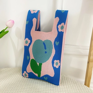 Close-up of knit tote bag with tulip and floral patterns in blue and pink finish