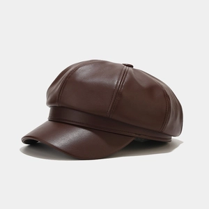 Detail shot of a dark brown leather octagonal newsboy hat with stitched panels and top button