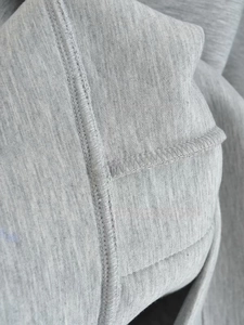 Detailed macro view of gray sweatshirt fabric showing precise stitching and knit texture