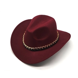 Close-up of wine red wide brim fedora hat featuring a chunky gold chain band detail